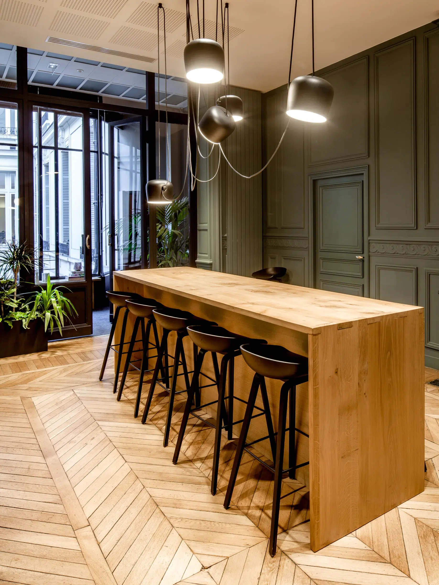 Espace de vie intérieur avec table haute et tabourets dans un immeuble professionnel
