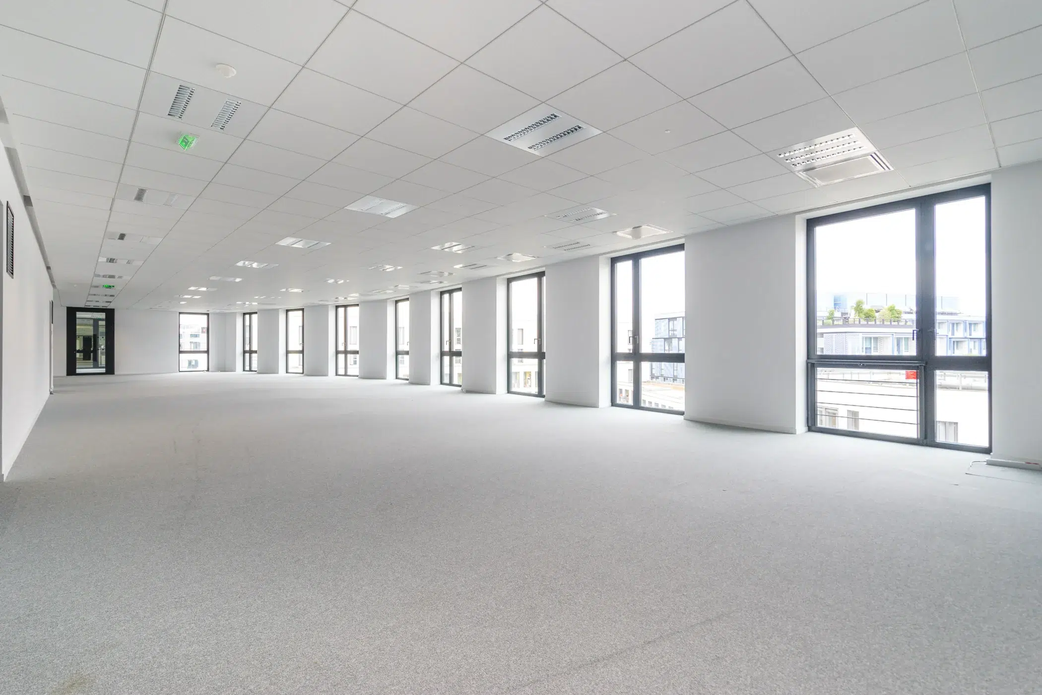 Grand plateau de bureaux vide avec moquette pour aménagement d’entreprise
