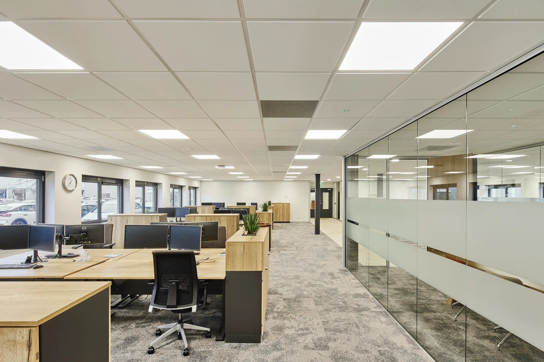 Grand open space avec salle de réunion vitrée dans un immeuble professionnel