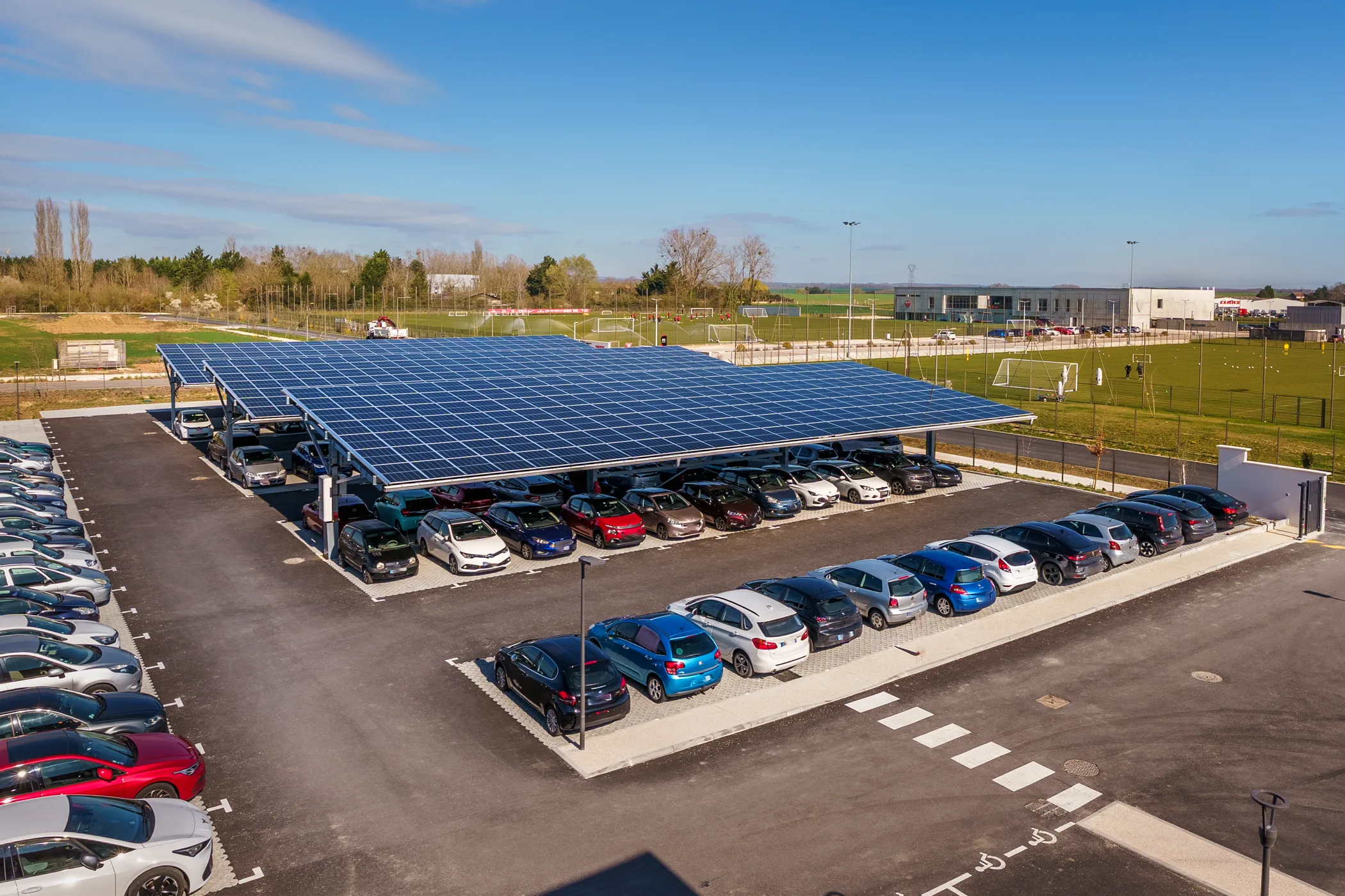 Parking extérieur avec voitures et ombrières photovoltaïques devant l’entreprise Filab à Saint-Apollinaire