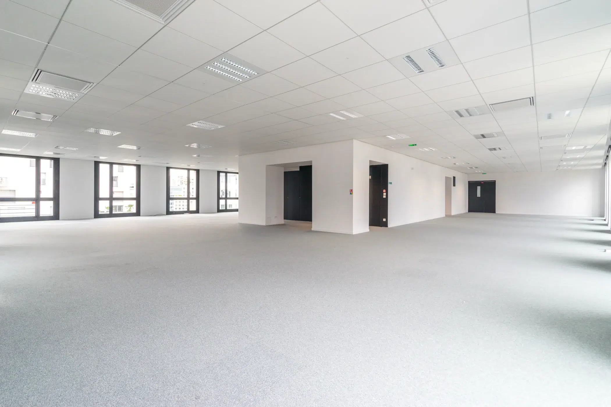 Grand plateau de bureaux vide avec moquette dans un espace professionnel