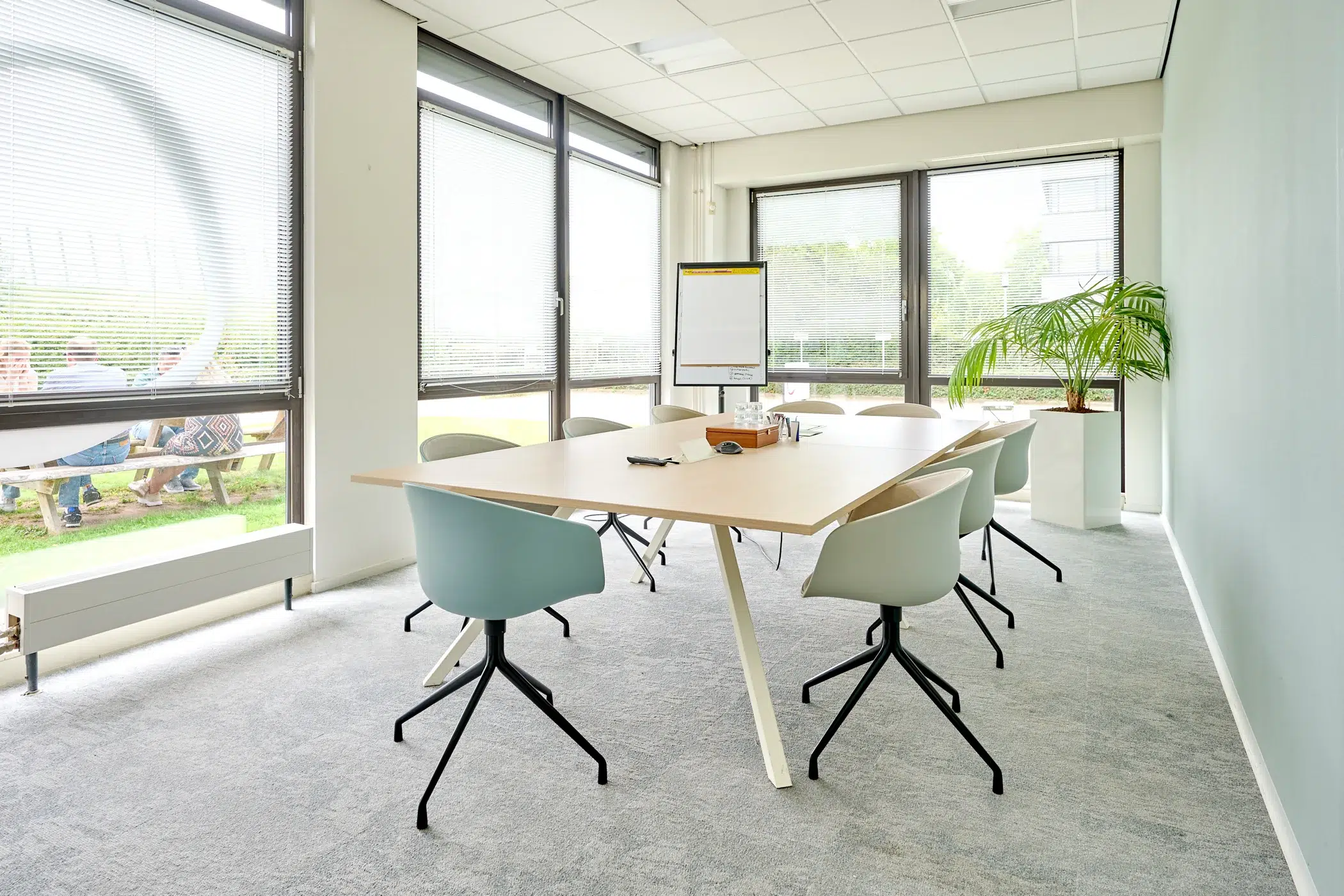 Salle de réunion avec table, chaises et paperboard dans un actif immobilier professionnel
