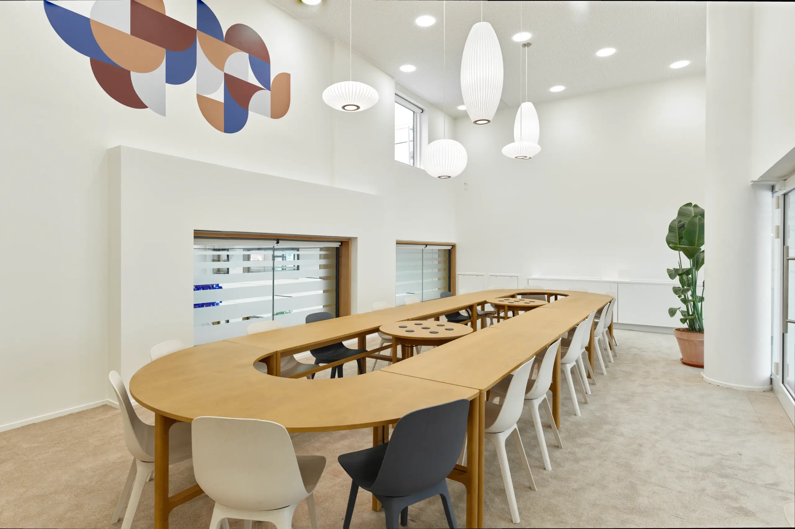 Salle de travail avec table ovale centrale et chaises dans un immeuble professionnel